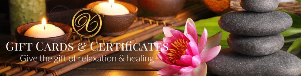 candles and rocks and a pink flower on bamboo sticks and text that says "gift cards and certificates give the gift of relaxation and healing".