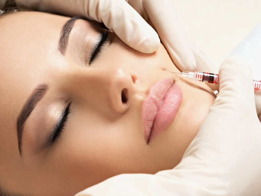 Close up of beautiful woman’s face receiving a syringe of Botox into cheek