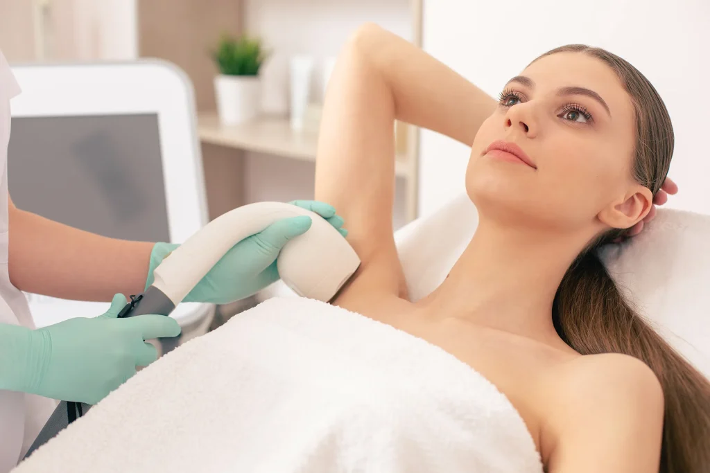 Young woman getting laser hair removal on her armpit