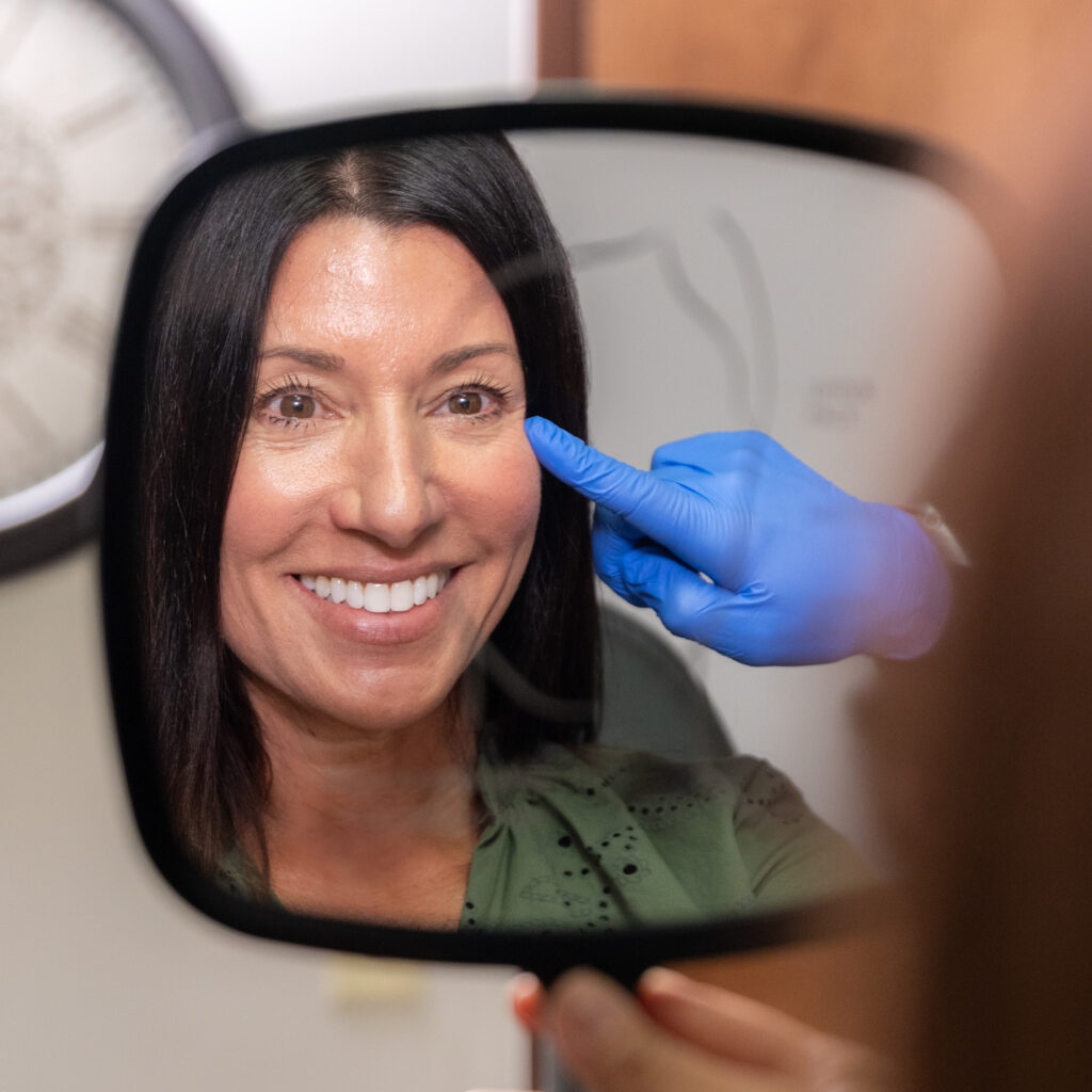 A woman is smiling after her treatment for ATTIVA skin tightening in Fort Collins.