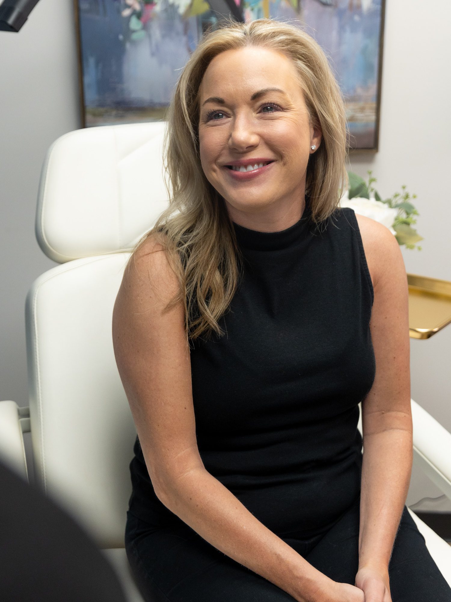 A woman is smiling before her treatment for ATTIVA skin tightening in Fort Collins.